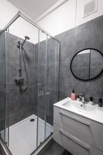 y baño con ducha, lavabo y espejo. en ClickTheFlat Wolska Apart Rooms, en Varsovia