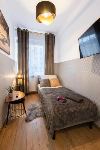 1 dormitorio con cama, mesa y ventana en ClickTheFlat Wolska Apart Rooms, en Varsovia