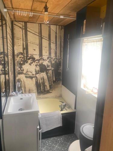 a bathroom with a sink and a picture of a group of people at La part des anges in Sainte-Marie-du-Mont
