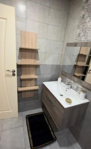 ein Bad mit einem Waschbecken und einem Spiegel in der Unterkunft Bel appartement in Zarzis