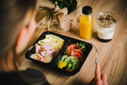 un bambino che tiene una forchetta davanti a un piatto di cibo di Tuyo Apartments Bokserska a Varsavia