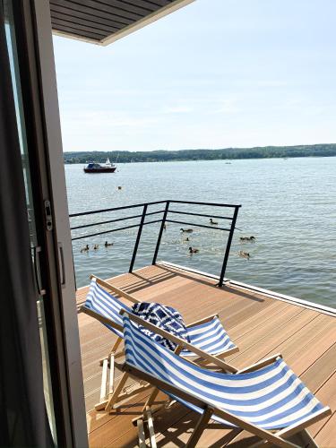 two chairs sitting on the deck of a boat at Domy na wodzie Charzykowy in Charzykowy