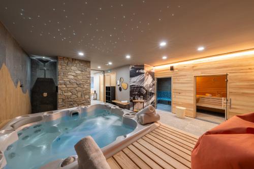 a jacuzzi tub in the middle of a room at Auberge Le Vieux Chaillol in Saint-Michel-de-Chaillol