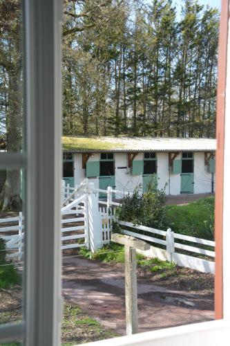 a white house with a white fence and a white gate at Domaine des cyprès in Vaudrimesnil