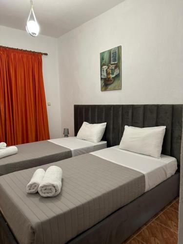 two beds in a hotel room with towels on them at Villa Xheni in Fshati i Ri