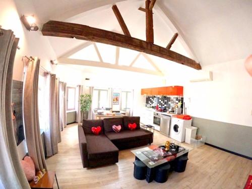 a living room with a couch and a table at Appartements de Charme DADOU MONS BELGIUM in Mons