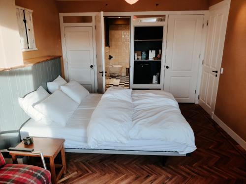 a large white bed in a room with a table at House of Straw Amsterdam in Amsterdam