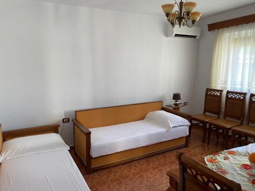 um quarto com duas camas e duas cadeiras em Stiven’s Apartment em Berat