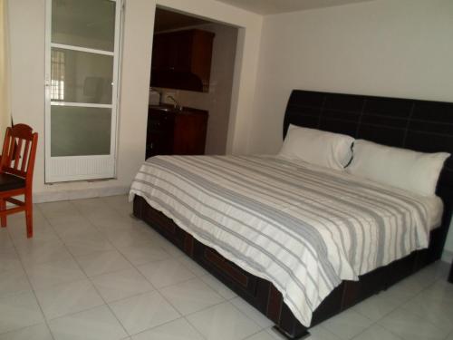 a bedroom with a bed and a chair and a window at Hotel María Bonita in Tlaxcala de Xicohténcatl