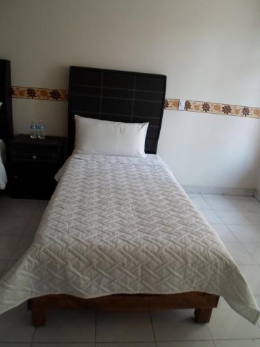 a bed with a black headboard in a bedroom at Hotel María Bonita in Tlaxcala de Xicohténcatl