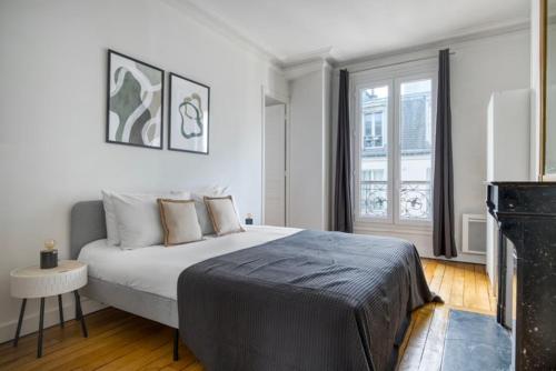 une chambre avec un grand lit et une fenêtre dans l'établissement Eiffel Tower / Tour Eiffel, à Paris