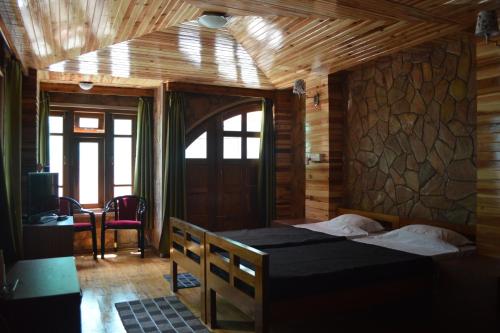 una camera con un letto in una stanza con pareti in legno di Quinton Enclave a Shillong