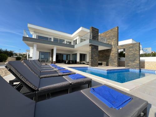 a villa with a swimming pool and lounge chairs at Luxury Modern Style Villa with Private Pool in Pêra