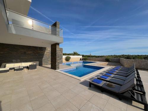 a villa with a swimming pool and a house at Luxury Modern Style Villa with Private Pool in Pêra