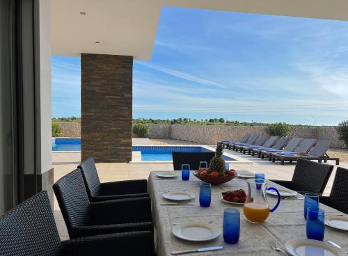 a table with a bowl of fruit on a patio at Luxury Modern Style Villa with Private Pool in Pêra