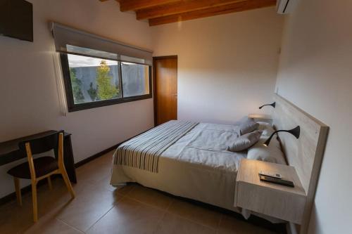a bedroom with a bed and a desk and a window at Estancia Yolanda C1-C2 10Pax - By Inside in Ciudad Lujan de Cuyo