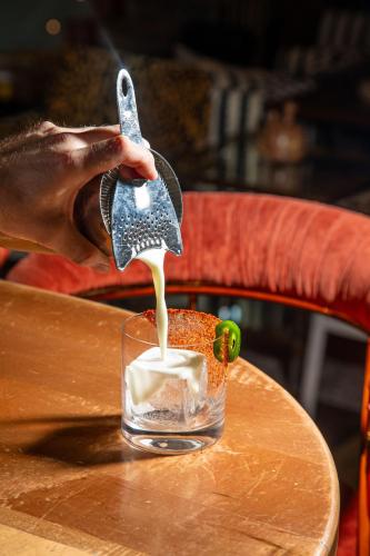 a person drinking milk from a glass on a table at Virgin Hotels New Orleans in New Orleans