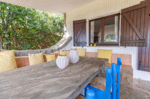 a large wooden table and chairs on a patio at SPLENDIDA VILLA SOS ARANZOS SPIAGGIA PRIVATA in Pittulongu