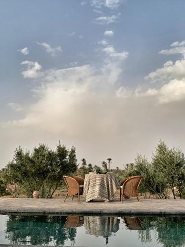 a table and chairs next to a pool of water at Dar faracha in Ouarzazate