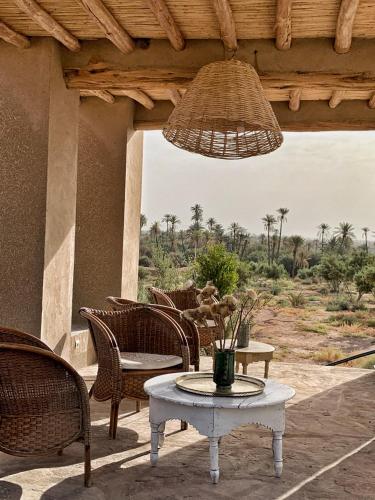 a patio with a table and chairs and a chandelier at Dar faracha in Ouarzazate
