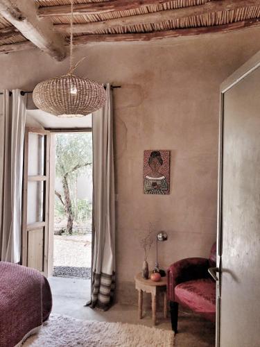 a bedroom with a bed and a chair and a table at Dar faracha in Ouarzazate