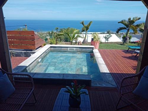 a swimming pool on a deck with a view of the ocean at La Villa Choka in Trois Bassins