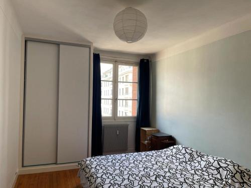 a bedroom with a bed and a large window at Chand Mama in Chambéry