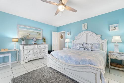 a blue bedroom with a bed and a ceiling fan at Phoenix VIII 81201 by Vacation Homes Collection in Orange Beach