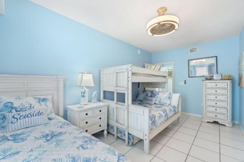 a bedroom with blue walls and a bed and a dresser at Phoenix VIII 81201 by Vacation Homes Collection in Orange Beach