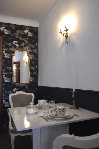 a dining room with a table and chairs and a mirror at Domaine des cyprès in Vaudrimesnil