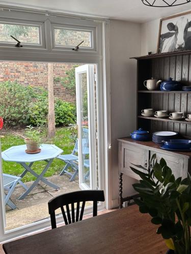 een eetkamer met een tafel en een raam bij Charming, Renovated Residence in Willesden Green in Londen