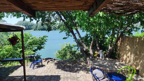 a patio with chairs and a view of a lake at Kuća za proslave i odmor ZMAJEVO GNEZDO in Pe°ani