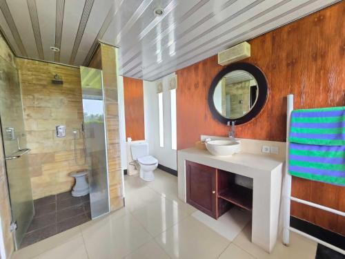 y baño con lavabo, ducha y espejo. en Belvilla 93799 Kasuari Villa Three Bedroom At Taro Village Ubud, en Penginyahan