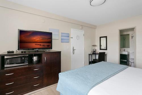 a bedroom with a bed and a flat screen tv at Hotel Sheldon in Hollywood