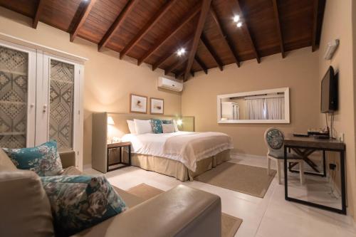 a bedroom with a bed and a tv and a couch at Faro Norte Suites in Asunción