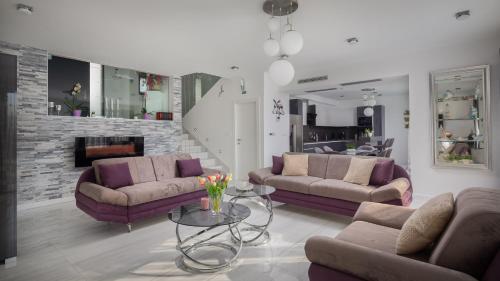 uma sala de estar com dois sofás e uma lareira em Villa Toma em Podstrana