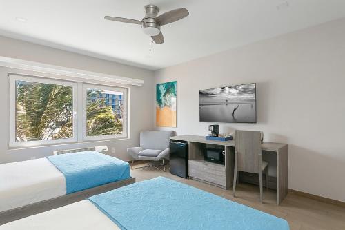 1 dormitorio con 1 cama y escritorio con TV en Hotel Sheldon, en Hollywood