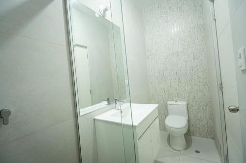 biała łazienka z toaletą i umywalką w obiekcie Casa Águila y Cóndor w mieście Lima