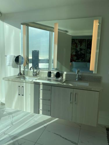 a bathroom with two sinks and a large window at Petco, City, Ocean Views! Gaslamp at it's finest! in San Diego