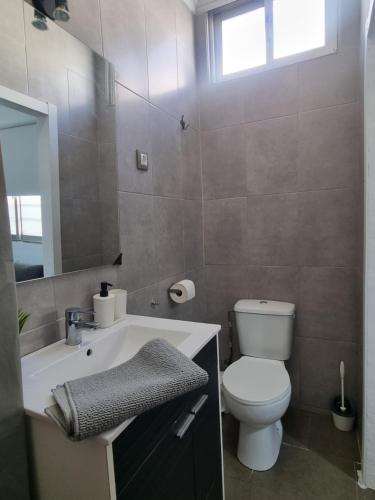 La salle de bains est pourvue de toilettes blanches et d'un lavabo. dans l'établissement Apartamento céntrico y sencillo en El Puerto, à El Puerto de Santa María