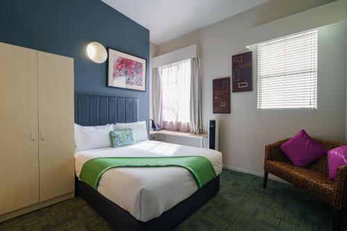 1 dormitorio con 1 cama grande y 1 silla en Ibis Styles Invercargill, en Invercargill