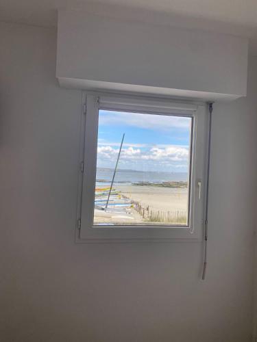 - une fenêtre dans une chambre avec vue sur la plage dans l'établissement Studio vue mer face à la plage, à Plougonvelin