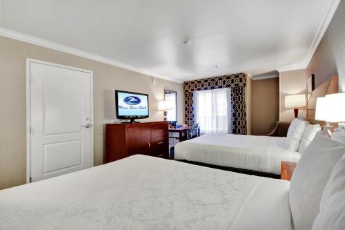 a hotel room with two beds and a television at Best Western Plus Marina Shores Hotel in Dana Point