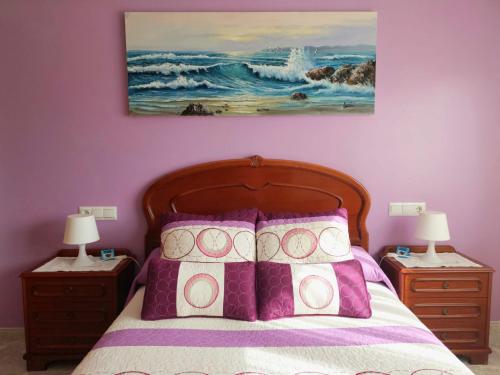 a bedroom with a bed with two night stands and two lamps at O Recuncho de Macías in Laxe