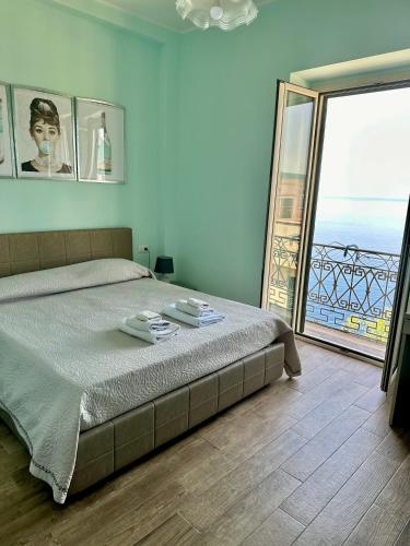a bedroom with a bed with a view of a balcony at Nel blu dipinto di blu in Scilla