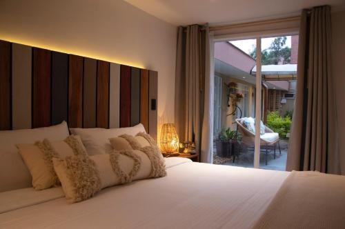 a bedroom with a white bed with a large window at Marbore hotel & Spa in Bogotá
