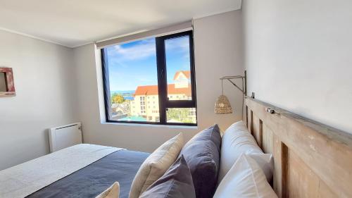a bedroom with a bed and a large window at La mejor ubicación y nuestro servicio 5 estrellas in Puerto Varas