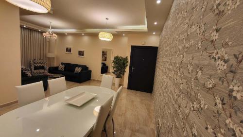 a living room with a white table and a wall at Western Gate Residence 2 Amman in Amman