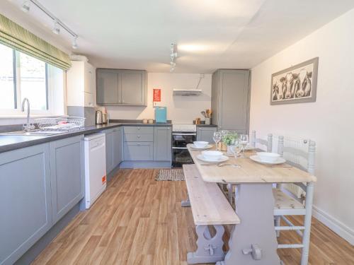 a kitchen with a wooden table and a dining room at 3 The Almshouse in Saxmundham