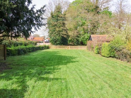 a yard with a fence and a green lawn at 3 The Almshouse in Saxmundham